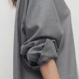 Side view of grey pino shirt on model, against a white background.