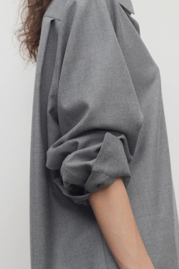 Side view of grey pino shirt on model, against a white background.