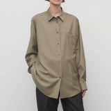 Front view of military beige pino shirt on model wearing grey pants, against a white background.