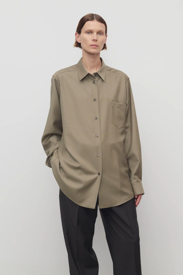 Front view of military beige pino shirt on model wearing grey pants, against a white background.