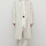 Front view of snow pluma coat on model wearing white top, pants and sneakers, against a white background.