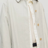 Front closeup view of snow pluma coat on model wearing white top and pants, against a white background.