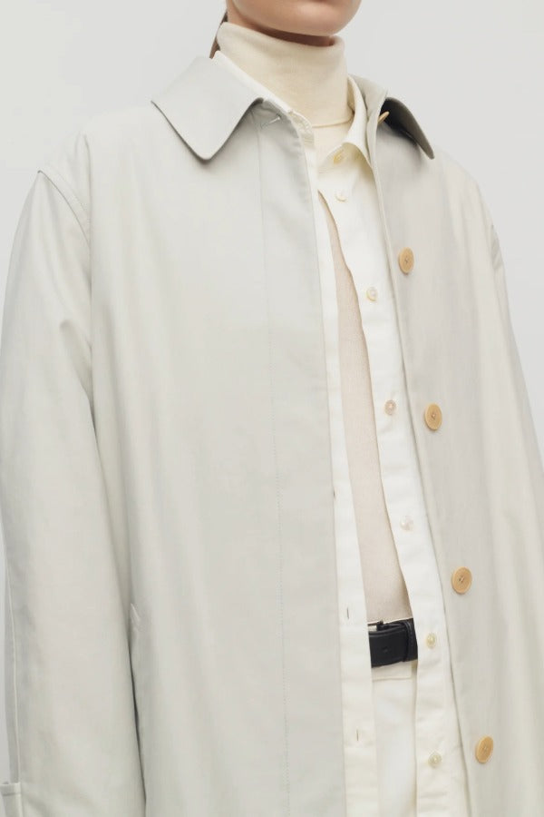 Front closeup view of snow pluma coat on model wearing white top and pants, against a white background.