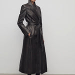 Front slanted view of coffee raisa coat on model wearing low heels, against a white background.