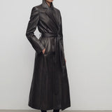 Front slanted view of coffee raisa coat on model wearing low heels, against a white background.