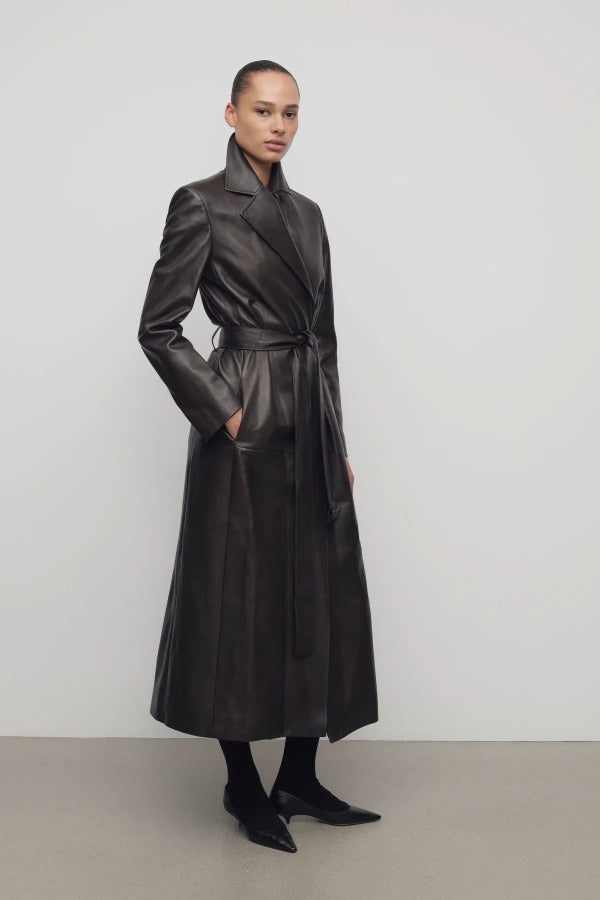 Front slanted view of coffee raisa coat on model wearing low heels, against a white background.