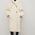 Front view of ivory regino coat on model wearing low heels, against a white background,