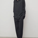 Front view of black relian pant on model wearing black shirt and heels, against a white background.