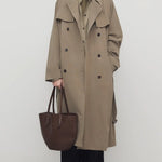 Front view of beige grey rhydian coat on model wearing black pants, against a white background.