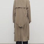 Back view of beige grey rhydian coat on model wearing black pants, against a white background.