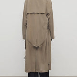 Back view of beige grey rhydian coat on model wearing black pants, against a white background.