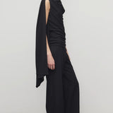 Side view of black roger pant on model wearing black top and heels, against a white background.