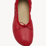 Overhead view of red round ballet flats on white background, with no model shown.