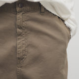 Front closeup view of taupe sharka pant on model wearing white t-shirt, against a white background.