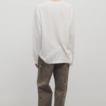 Back view of taupe sharka pant on model wearing white t-shirt and slides, against a white background.