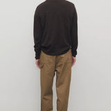 Back view of dark sand sharka pant on model wearing black shirt, against a white background.