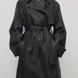 Front view of black siempra coat on model, against a white background.