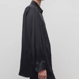 Side view of black sisilia shirt on model wearing black pants, against a white background.