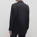 Back view of black sisilia shirt on model wearing black pants, against a white background.