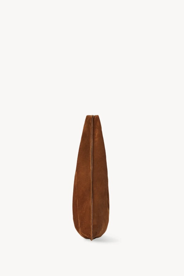 Side view of bistre small suede bindle bag on white background, with no model shown.