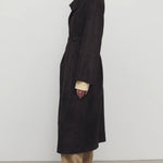 Side view of dark brown solana coat on model wearing khaki pants and mules, against a white background.