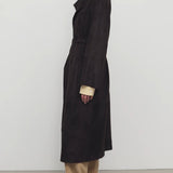 Side view of dark brown solana coat on model wearing khaki pants and mules, against a white background.