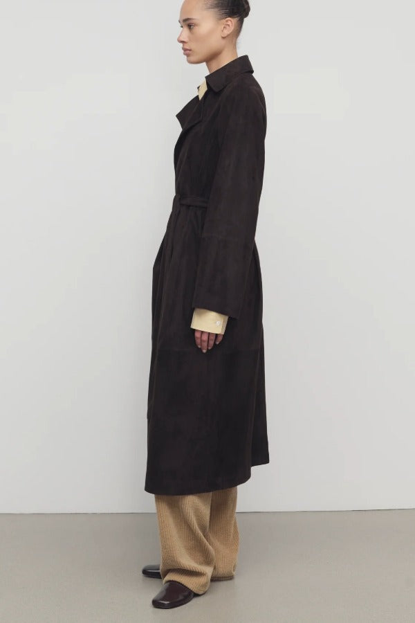 Side view of dark brown solana coat on model wearing khaki pants and mules, against a white background.
