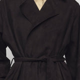 Front closeup view of dark brown solana coat on model wearing yellow shirt, against a white background.