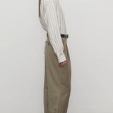 Side view of military beige sorina pant on model wearing a striped shirt and flats, against a white background.