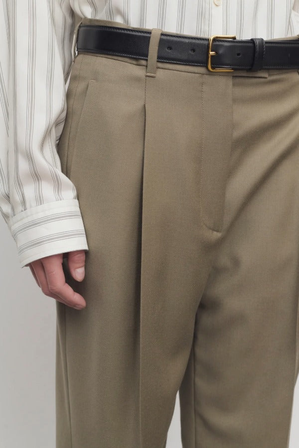 Front closeup of military beige sorina pants on model wearing striped shirt and black belt, against a white background.