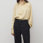 Front view of sand takara shirt on model wearing black pants and black belt, against a white background.