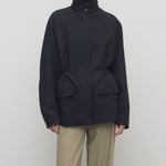 Front view of navy tanera jacket on model wearing khaki pants, against a white background.