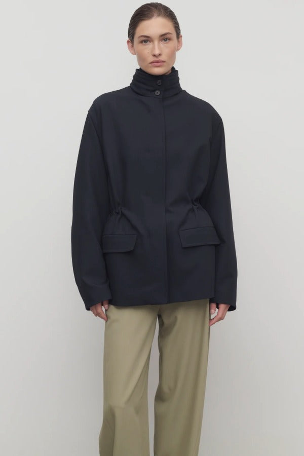 Front view of navy tanera jacket on model wearing khaki pants, against a white background.