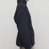 Side view of navy tanera jacket on model wearing khaki pants, against a white background.