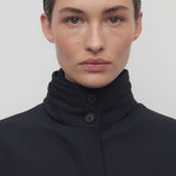 Front closeup view of navy tanera jacket on model, against a white background.