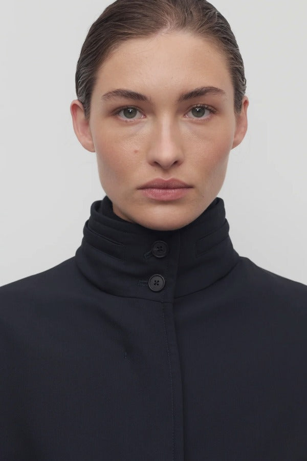 Front closeup view of navy tanera jacket on model, against a white background.