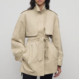 Front view of sandstone tavoris jacket on model wearing black leggings, against a white background.