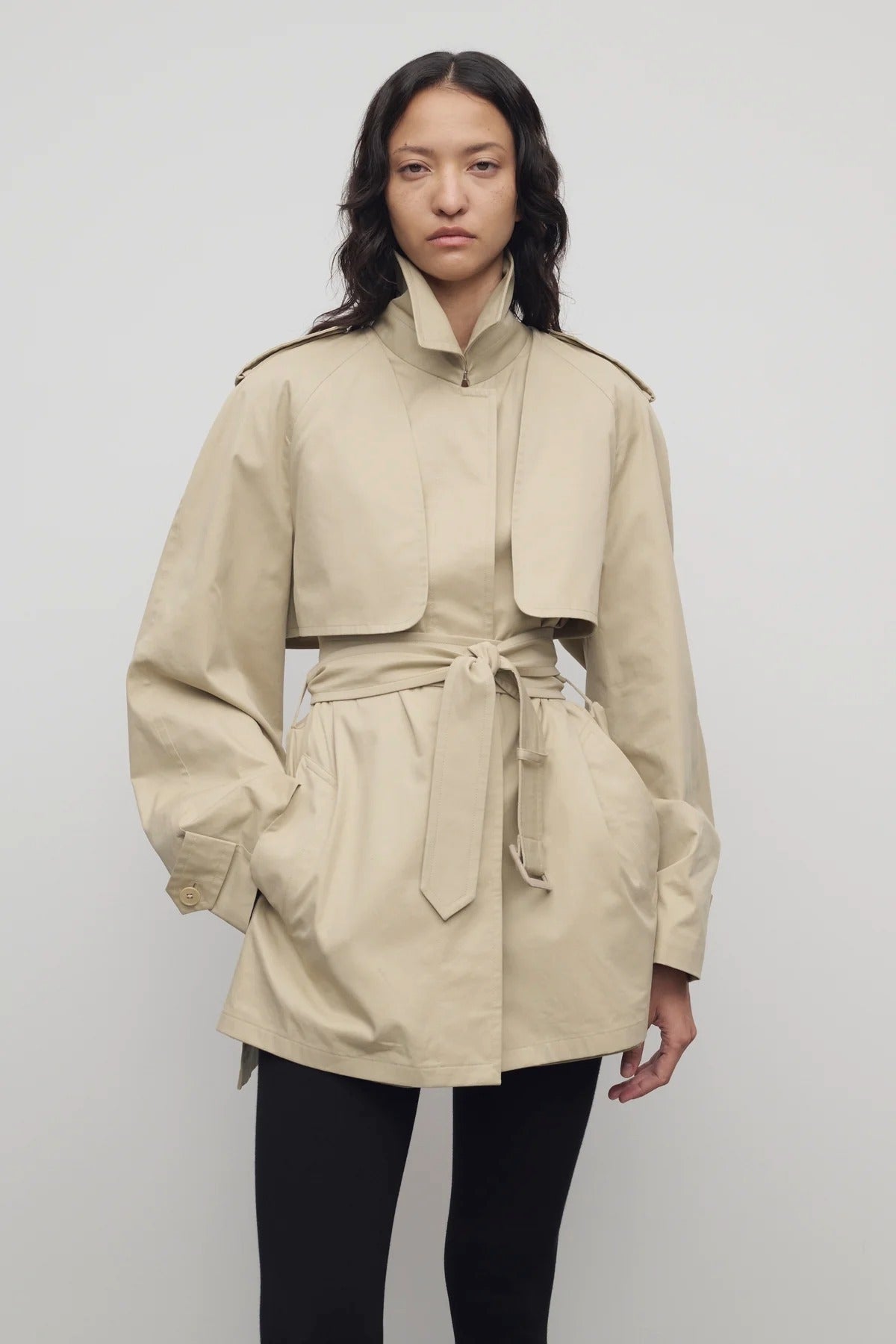 Front view of sandstone tavoris jacket on model wearing black leggings, against a white background.