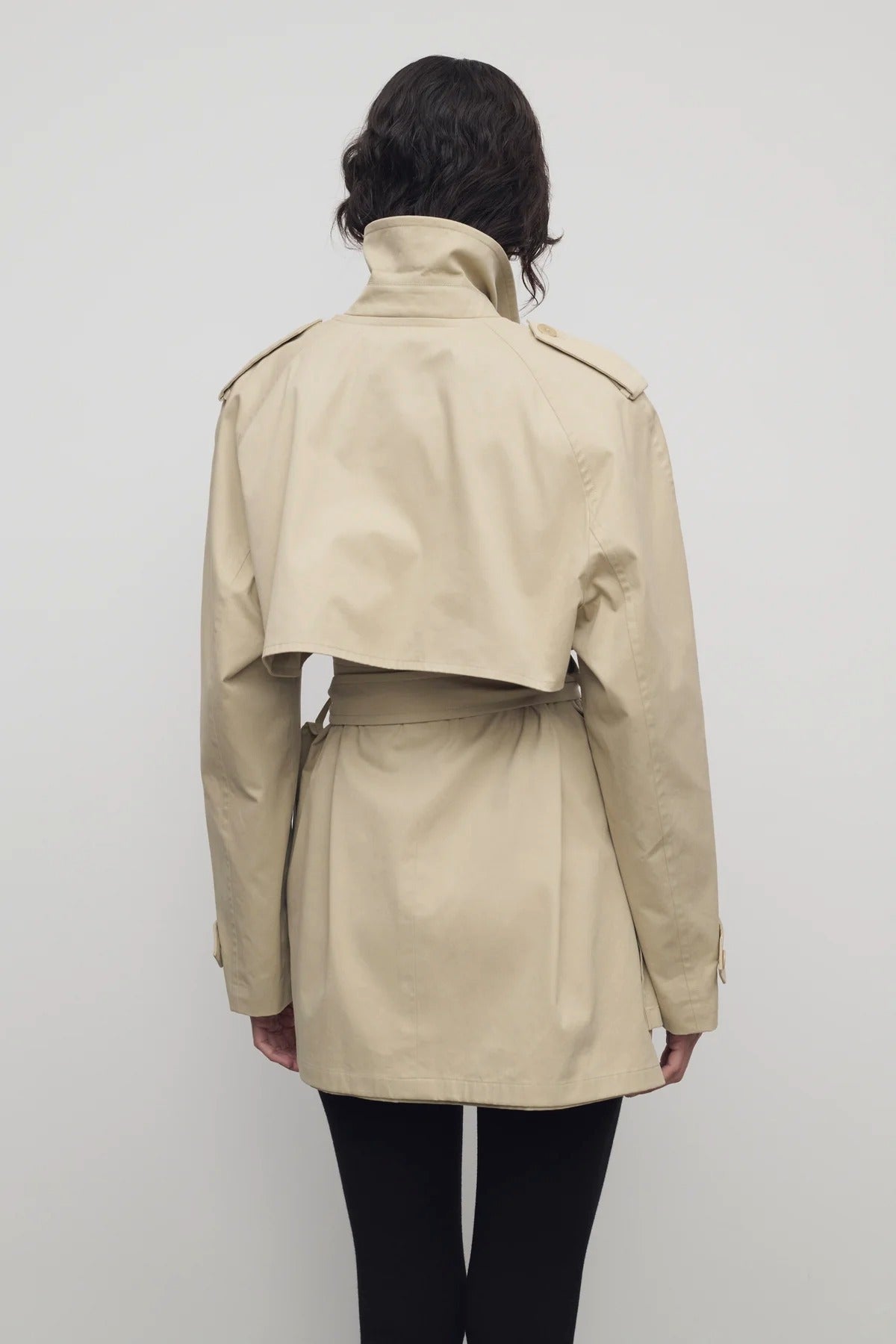 Back view of sandstone tavoris jacket on model wearing black leggings, against a white background.