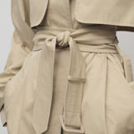 Front closeup of belt in sandstone tavoris jacket on model against a white background.
