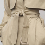 Front closeup of belt in sandstone tavoris jacket on model against a white background.