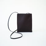 Front view of black leather bag on white background, with no model shown.