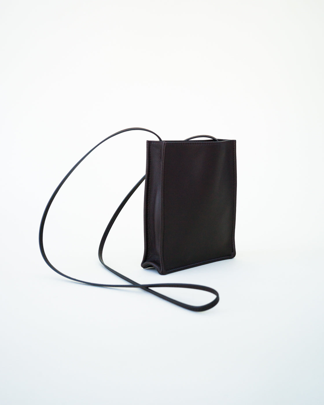 Side slanted view of black leather bag on white background, with no model shown.