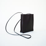 Side slanted view of black leather bag on white background, with no model shown.