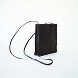 Side slanted view of black leather bag on white background, with no model shown.