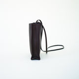 Side view of black leather bag on white background, with no model shown.