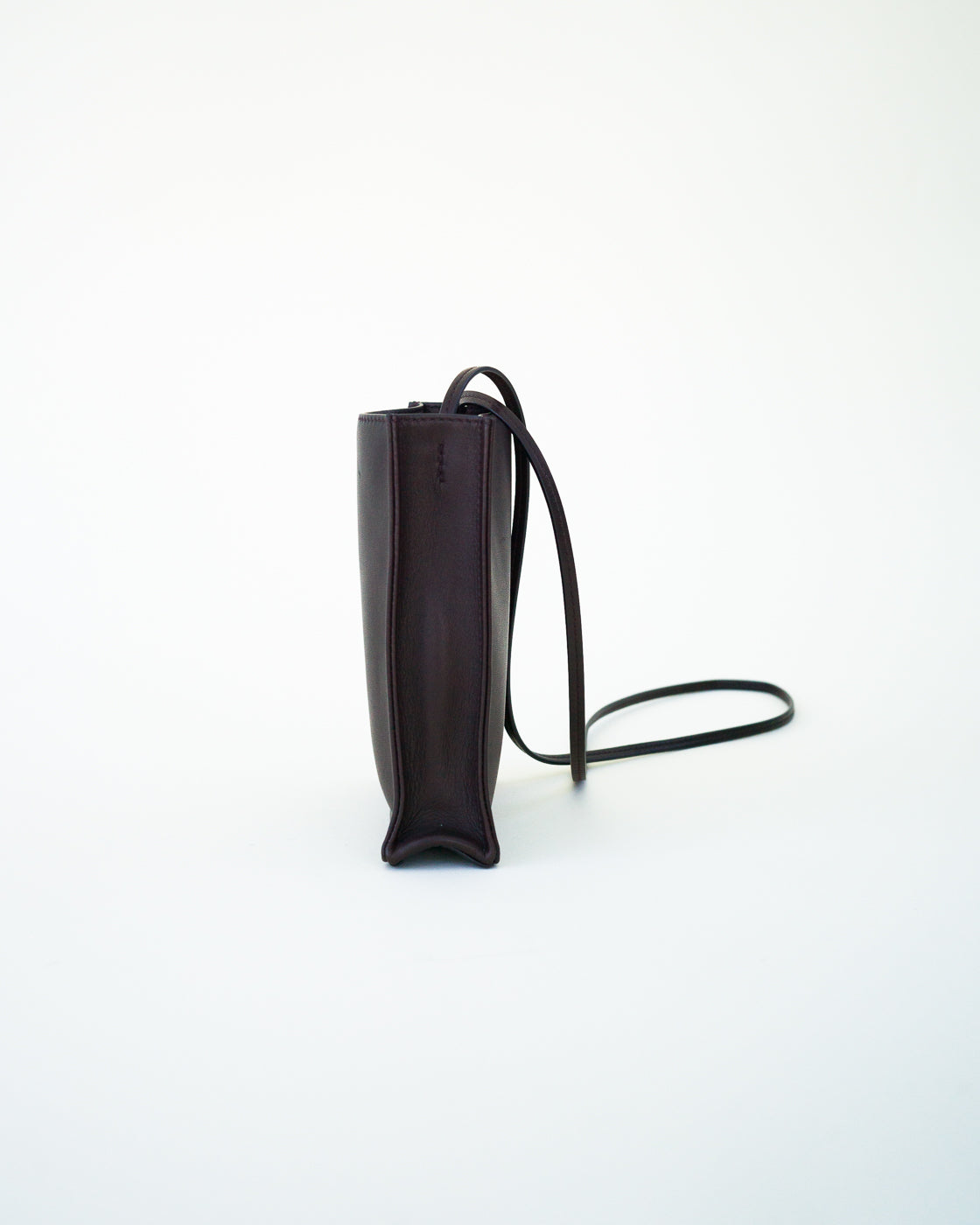 Side view of black leather bag on white background, with no model shown.
