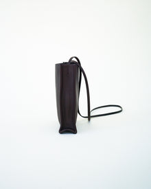 Side view of black leather bag on white background, with no model shown.