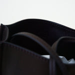 Closeup view of black leather bag on white background, with no model shown.