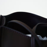 Closeup view of black leather bag on white background, with no model shown.